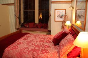 a bedroom with a bed and a window with a couch at Villa Rouge B&B in Invercargill