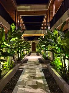 a hallway of a building with plants on each side at Kuda Putih Guest House Pandawa in Ungasan