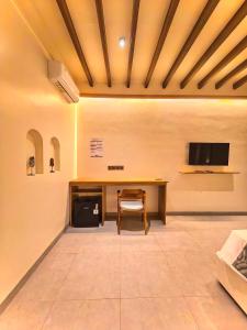 a room with a desk and a tv on a wall at Kuda Putih Guest House Pandawa in Ungasan