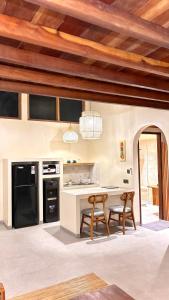 a kitchen with a table and chairs in a room at Kuda Putih Guest House Pandawa in Ungasan