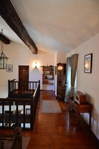 a living room with a wooden floor and a staircase at L'Oustal des Rameaux in Brissac