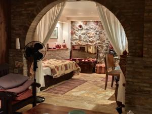 a bedroom with a bed and a stone wall at villa eleni in Sounio +50 photos