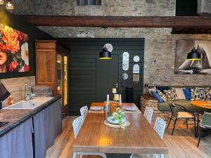 a kitchen and dining room with a wooden table at Suite parentale avec un petit salon in Homps