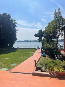 a brick walkway next to a park with a view of the water at Lakefront holiday in Salò