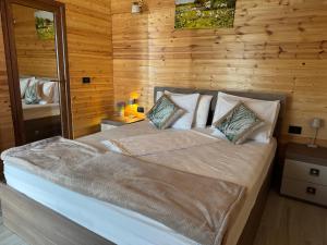 a bedroom with a large bed with wooden walls at La samba in Crisan +20 photos