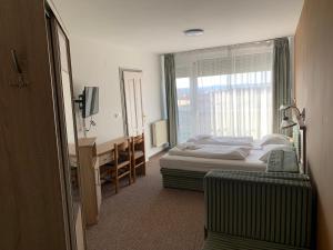 a hotel room with a bed and a window at Várfal Panzió és Wellness in Pécs