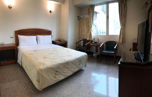 a hotel room with a bed and a desk and a television at Chantai Hotel in Hualien City