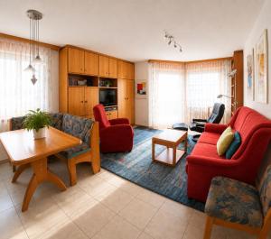 a living room with red furniture and a table at Residenz Darianne Leukerbad in Leukerbad