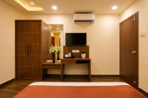 a bedroom with a desk and a tv and a room at Hotel Shiv Shakti in Rajkot