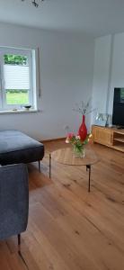 a living room with a table with a vase on it at Top Ferienwohnung Herborn in Herborn