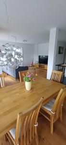 a wooden table with chairs and a vase with flowers on it at Top Ferienwohnung Herborn in Herborn