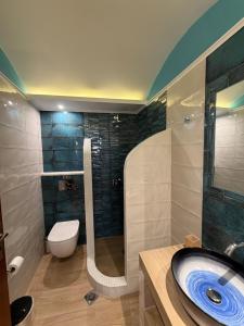 a bathroom with a sink and a toilet and a shower at Leonidas Apartments in Kamari