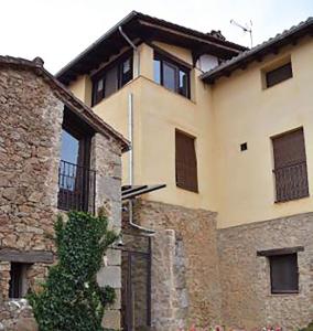 a large stone building with a gate in front of it at Casa Rural Hosteria Cantarranas in Cuacos de Yuste