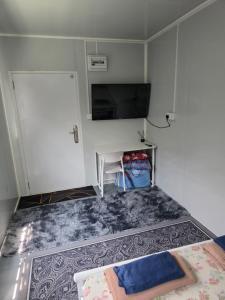 a room with a tv and a table and a couch at Kabin Bangau Parit in Temerloh +9 photos