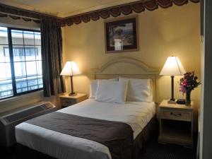 a hotel room with a large bed with two lamps at San Francisco Inn in San Francisco