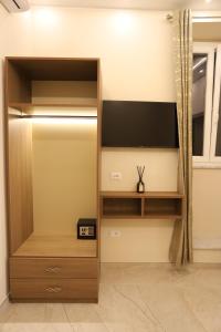 a large wooden cabinet with a tv in a room at Palazzo Campisi rooms in Tropea