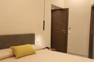 a bedroom with a bed with a yellow pillow on it at Palazzo Campisi rooms in Tropea