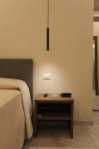 a bedroom with a bed and a wooden night stand at Palazzo Campisi rooms in Tropea