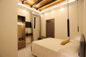 a bedroom with a bed with a yellow pillow on it at Palazzo Campisi rooms in Tropea +123 photos