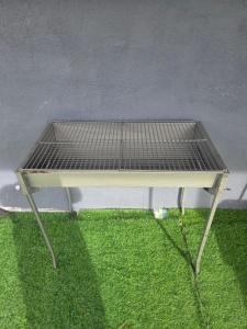 a barbecue grill sitting on top of green grass at Kabin Bangau Parit in Temerloh