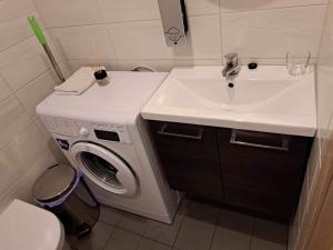 a bathroom with a sink and a washing machine at Aisa Street apartments in Pärnu