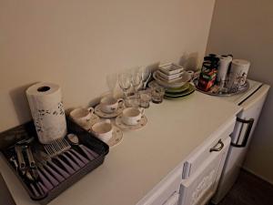 a kitchen counter with cups and plates and glasses at Aisa Street apartments in Pärnu