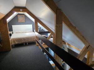 a attic room with a bed and a staircase at Kouwenberg in Aarle-Rixtel