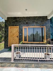 a house with a wooden door and a fence at Ekantam Mountain Cottages in Dehradun