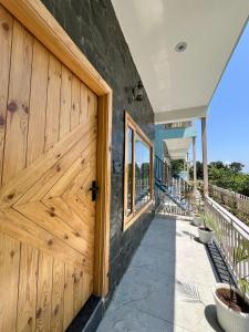 a wooden door on a house with a porch at Ekantam Mountain Cottages in Dehradun