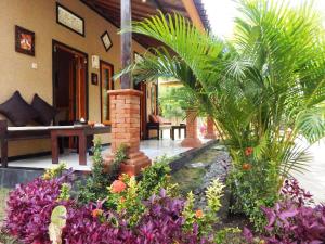 een huis met een binnenplaats met planten en bloemen bij Yuda Menjangan Homestay in Banyuwedang