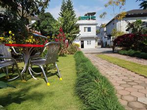 a table and chairs in a garden with a pathway at Hotel Bishram in Pokhara