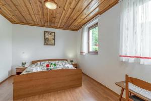 a bedroom with a bed and a wooden ceiling at Vrtin Vineyard Family Retreat - Happy Rentals in Dragatuš