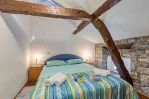 a bedroom with a bed with towels on it at Tourist Farm Pri Živcovih in Dutovlje