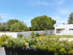 a garden in front of a white fence at LES MAISONS DU PATY in Arles