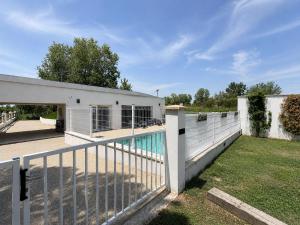 a house with a fence and a swimming pool at LES MAISONS DU PATY in Arles