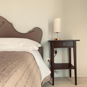 a bed with a night stand next to a table with a lamp at Etna Rooftop in Trecastagni