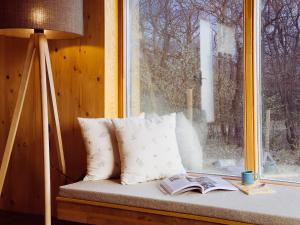 a window seat with pillows and a lamp and a book at Öreg-kő 1478 in Bajót