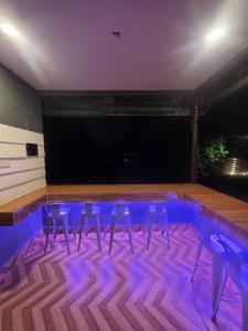 a dance floor with three stools and a stage at Kabin Bangau Parit in Temerloh