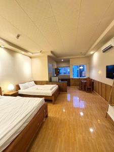 a large room with two beds and a television at 5 homestay central in Vung Tau