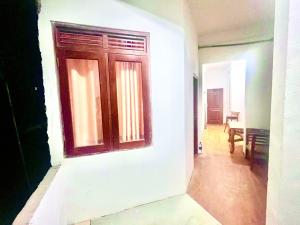 a white wall with a wooden door in a hallway at Studio Greenlands 2nd-E in Battaramulla