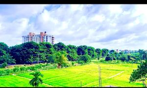 a large green field with a building in the background at Studio Greenlands 2nd-E in Battaramulla +4 photos