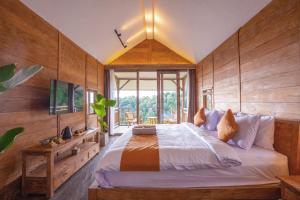 a bedroom with a large bed with wooden walls at Ocean & Mountain View Villa, Waterfalls, Munduk Eco-Luxe by Santrian in Munduk +28 photos