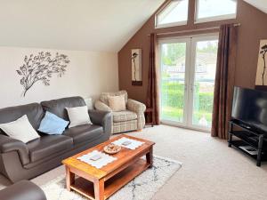 a living room with a couch and a table at caddys lodge in Tydd Saint Giles