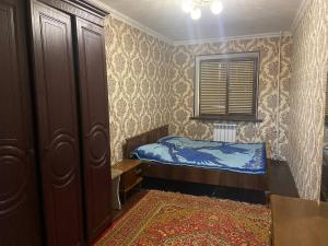 a small bedroom with a bed and a window at Samarkand,Uzbekistan in Samarkand