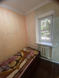 a small bedroom with a bed with a flower blanket at Samarkand,Uzbekistan in Samarkand