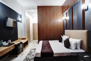 a hotel room with a bed and a television at Hotel Rivlet By Carlton Suites in Gurgaon