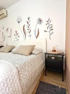 a bedroom with a bed with flowers on the wall at Studio Izola in Izola