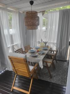 a dining table and chairs in a room with white curtains at Mobilheim ANDREA wunderschöne Ferienwohnung direkt am Meer in Jezera +31 photos