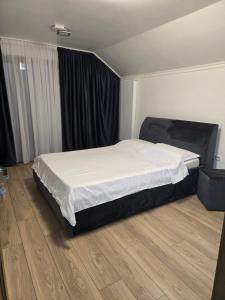 a bedroom with a large bed with white sheets at Casa Roberto in Budeşti