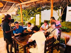 a group of people sitting at a table in a restaurant at Baywatch Arugambay in Arugam Bay